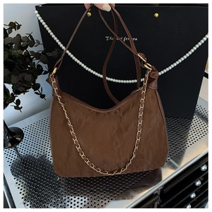 Détail du sac cabas plissé marron foncé avec chaîne dorée et texture vintage