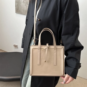 Minimalist beige structured square handbag with embossed frame and double ring handles