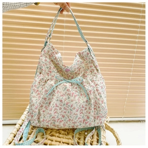 Floral canvas tote bag in cream white with blue gingham bows and drawstring bucket design