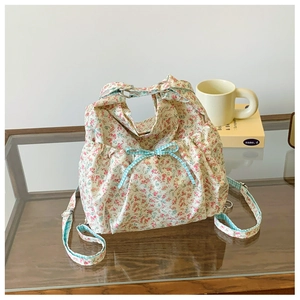 Detail of floral canvas bag featuring a light blue checkered bow and ruffles