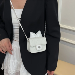 Sac bandoulière blanc matelassé avec nœud 3D et fermoir camélia porté par un modèle