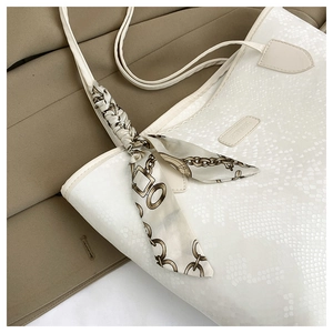 Dettaglio borsa tote bianca motivo coccodrillo con sciarpa decorativa in seta marrone