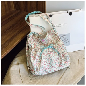 Floral tote bag detail featuring blue checkered bow and pink resin snap closure button