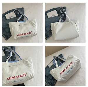 Detailed views of cream canvas tote bag with Crème Glacée print and blue striped handles