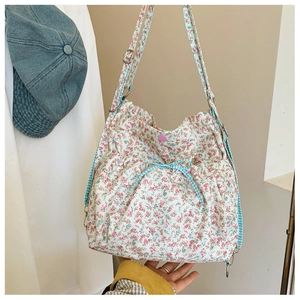 Detail of floral tote bag with blue checkered bow and pink metallic snap button closure