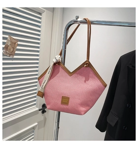 Detail der rosa geflochtenen Tragetasche mit Lederriemen und bedrucktem Seidenschal-Accessoire