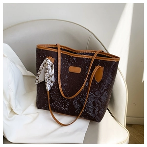 Dettaglio borsa tote con motivo serpente, patch in pelle e sciarpa di seta decorativa