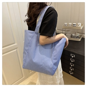 Macro shot of large capacity tote bag featuring classic blue and white vertical stripes
