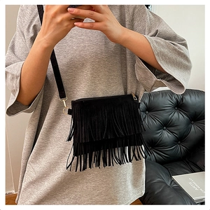 Détail du sac à bandoulière bohème noir avec de longues franges et des boucles dorées