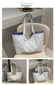 Macro shot of white canvas tote bag with red text and blue striped lining detail