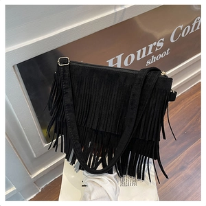 Détail du sac bandoulière bohème en daim noir avec franges étagées et fermetures dorées