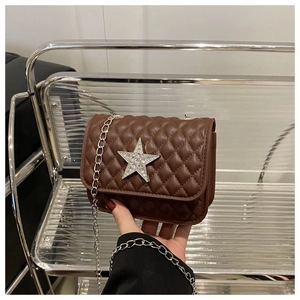 Détail d'un petit sac carré marron matelassé avec étoile en strass et chaîne en métal