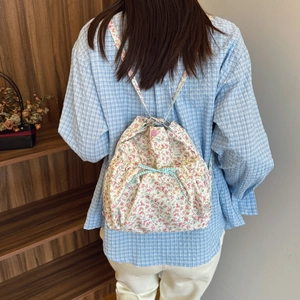 Floral drawstring backpack with pink flowers and a blue checkered ribbon bow