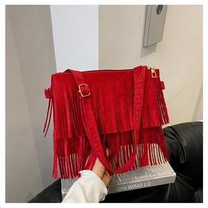 Détail du sac bandoulière en daim rouge avec franges denses et fermeture éclair dorée