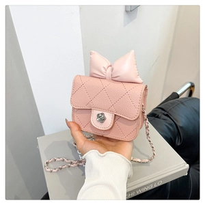 Pink mini quilted crossbody bag with decorative bow and camellia metal clasp