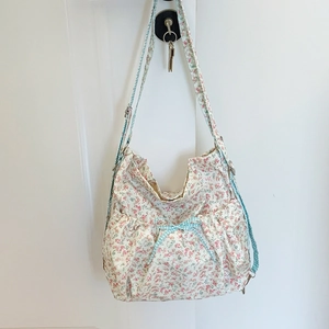 Floral canvas backpack with blue bow and adjustable shoulder strap in cream white