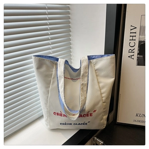 Detail of white canvas tote bag showing striped lining and Crème Glacée print
