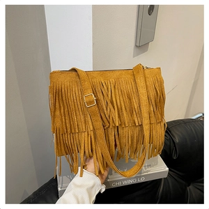 Détail du sac bohème en daim marron avec de longues franges doubles et une boucle de sangle