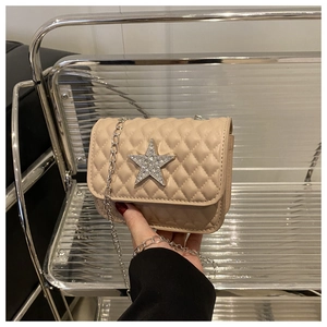 Détail du mini sac beige matelassé avec étoile en strass argentée et bandoulière chaîne