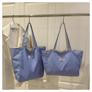 Detail of blue and white striped canvas tote bags in two sizes for daily commuting