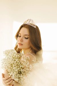 Close-up of golden bridal tiara with light purple and white crystals on a model
