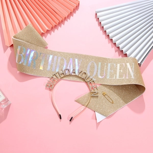 Dettaglio fascia glitter Birthday Queen e tiara di strass su sfondo rosa decorativo