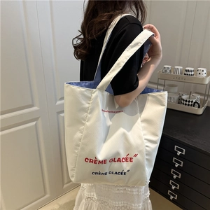 Minimalist white canvas tote bag with French print and striped lining for casual daily use