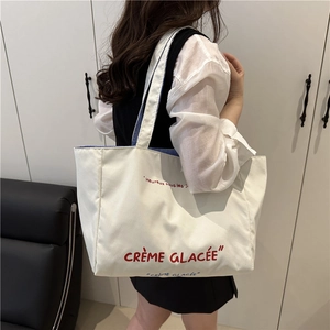 Minimalist white canvas tote bag with red Crème Glacée print and blue striped strap