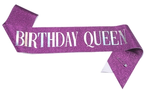 Detail of purple glitter Birthday Queen sash with shiny silver letters and safety pin