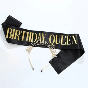 Dettaglio fascia Birthday Queen in raso nero con testo dorato e cerchietto con strass