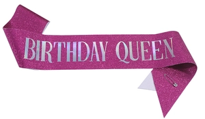 Pink glitter sash with silver Birthday Queen lettering and a metal safety pin accessory
