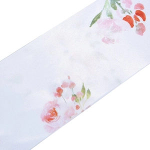 Detailed view of floral satin sash featuring pink roses and green leaves on white fabric