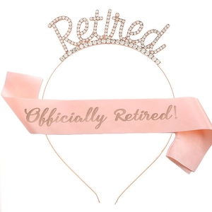 Close-up of rose gold Retired rhinestone crown and pink Officially Retired satin sash set