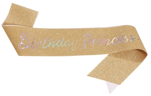Close-up of glittery golden birthday princess sash with iridescent holographic font