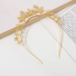 Detail of gold star headband with embedded rhinestones and pearls on a white background