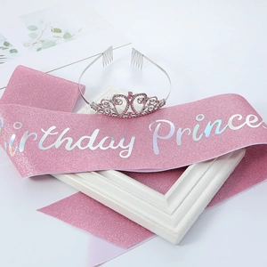 Detailed shot of a pink glitter birthday sash and a silver crown with pink rhinestones