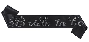 Detalle de banda Bride to be de satén negro con letras de pedrería para despedidas