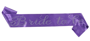 Detalle de banda de satén morada con letras Bride to be en pedrería brillante para bodas