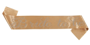 Detalle de banda de satén champán con letras Bride to be en diamantes para despedidas