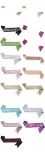 Close-up of Birthday Queen sashes in various glitter colors with safety pins