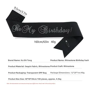 Detail of black glitter fabric birthday sash with silver rhinestone lettering and safety pin
