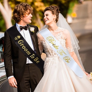 Close-up of Groom To Be and Bride To Be satin sashes with elegant gold foil lettering