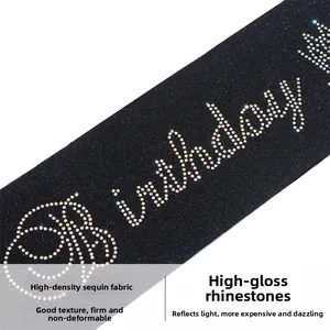 Detail of black glitter fabric birthday sash with shiny rhinestone lettering and crown
