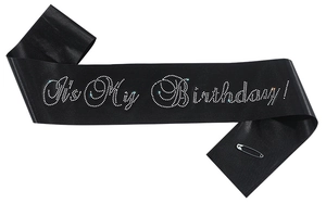 Detail of black satin birthday sash with It's My Birthday white rhinestone lettering