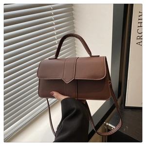 Details der braunen Vintage-Handtasche aus Leder mit Riemen und Magnetverschluss