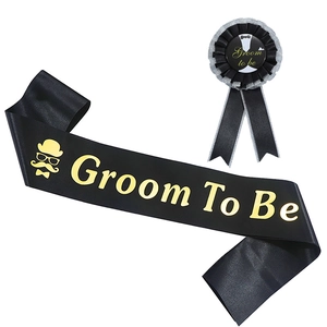Close-up of Groom To Be black satin sash and matching rosette badge with gold lettering
