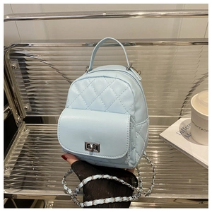 Detail view of light blue quilted leather backpack with silver twist lock and chain strap
