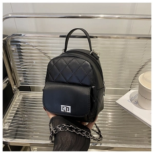 Close-up of black quilted leather backpack with silver twist lock and chain strap