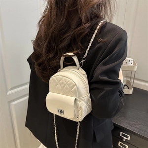Cream quilted mini backpack with chain straps and metallic lock for a modern style