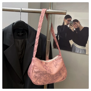 Detail of pink satin underarm bag with bamboo leaf print and smooth zipper closure
